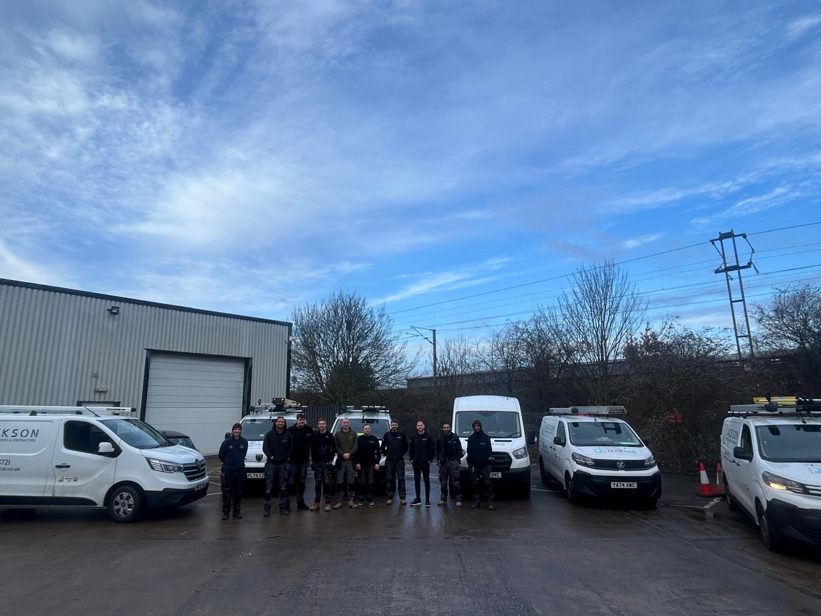 Jackson Electrical team standing in front of company vans.