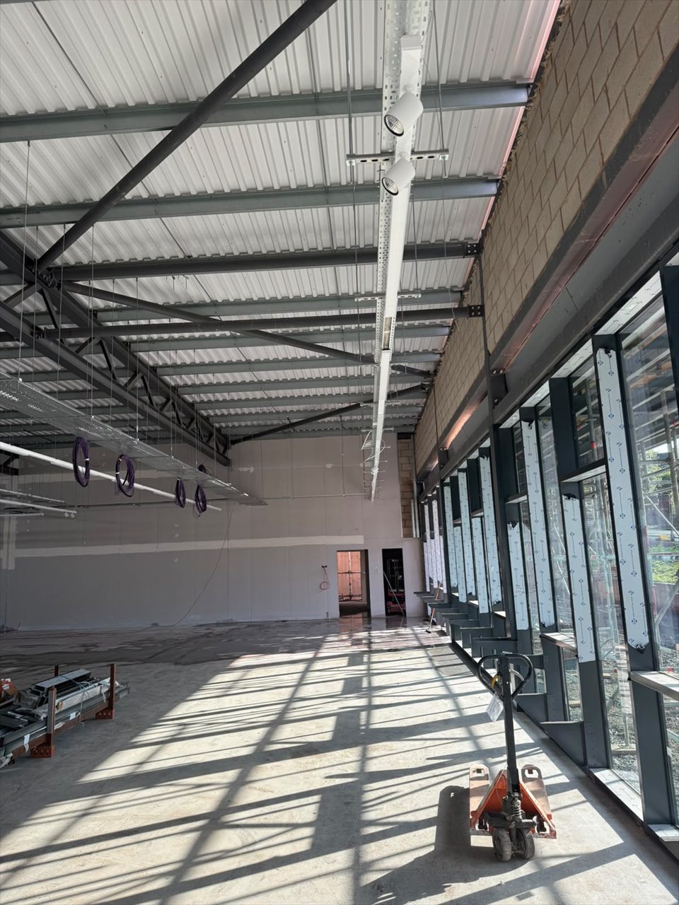 Shop floor, high-level lighting and window-side electrical installation work in progress at Aldi Lower Gornal